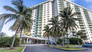 A high-rise hotel with multiple balconies, palm trees, and a covered entrance. - Awesome Miami Sunny Isles Ocean Reserve Condo (Sunny Isles Beach)
