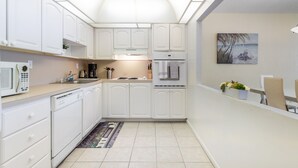 A modern kitchen with white cabinetry, a built-in microwave, and a coffee maker. - Awesome Miami Sunny Isles Ocean Reserve Condo (Sunny Isles Beach)
