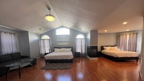 A spacious room with a high ceiling, two beds, a sofa, and a TV. - SPACIOUS Single Home near DC & National Harbor (Fort Washington)