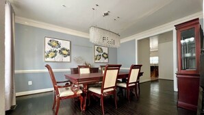 A dining room with a wooden table and chairs, a chandelier, and floral artwork on the walls. - SPACIOUS Single Home near DC & National Harbor (Fort Washington)