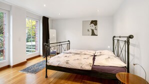 A bedroom with a bed, a window, and a door. - Apartment 'Grüne Oase In Der Großstadt' with Private Terrace, Garden and Wi-Fi (Berlin)