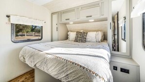 A bedroom with a bed, a window, and a mirror. - Desert Tiny Home B25: Relaxing Desert Accommodation w/ Comfort Amenities (Jacumba Hot Springs)