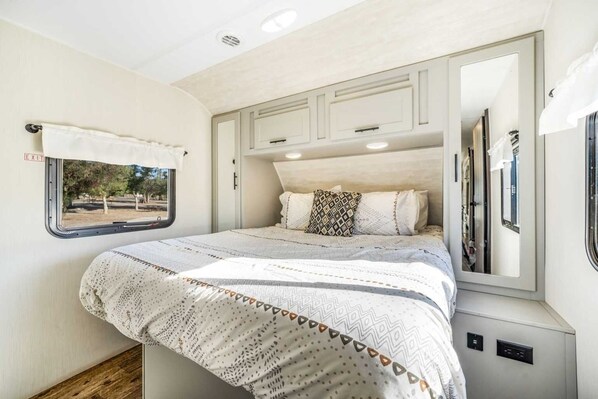 A bedroom with a bed, a window, and a mirror. - Desert Tiny Home B25: Relaxing Desert Accommodation w/ Comfort Amenities (Jacumba Hot Springs)