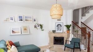 Ein modernes Wohnzimmer mit einem grünen Sofa, einem runden Glastisch und einem Kamin.