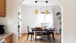 Ein Essbereich mit Holztisch, Stühlen und hängenden Korbtischen.