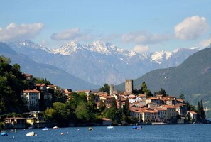 Eine Küstenstadt mit historischen Gebäuden, einer Burg und Bergen im Hintergrund.