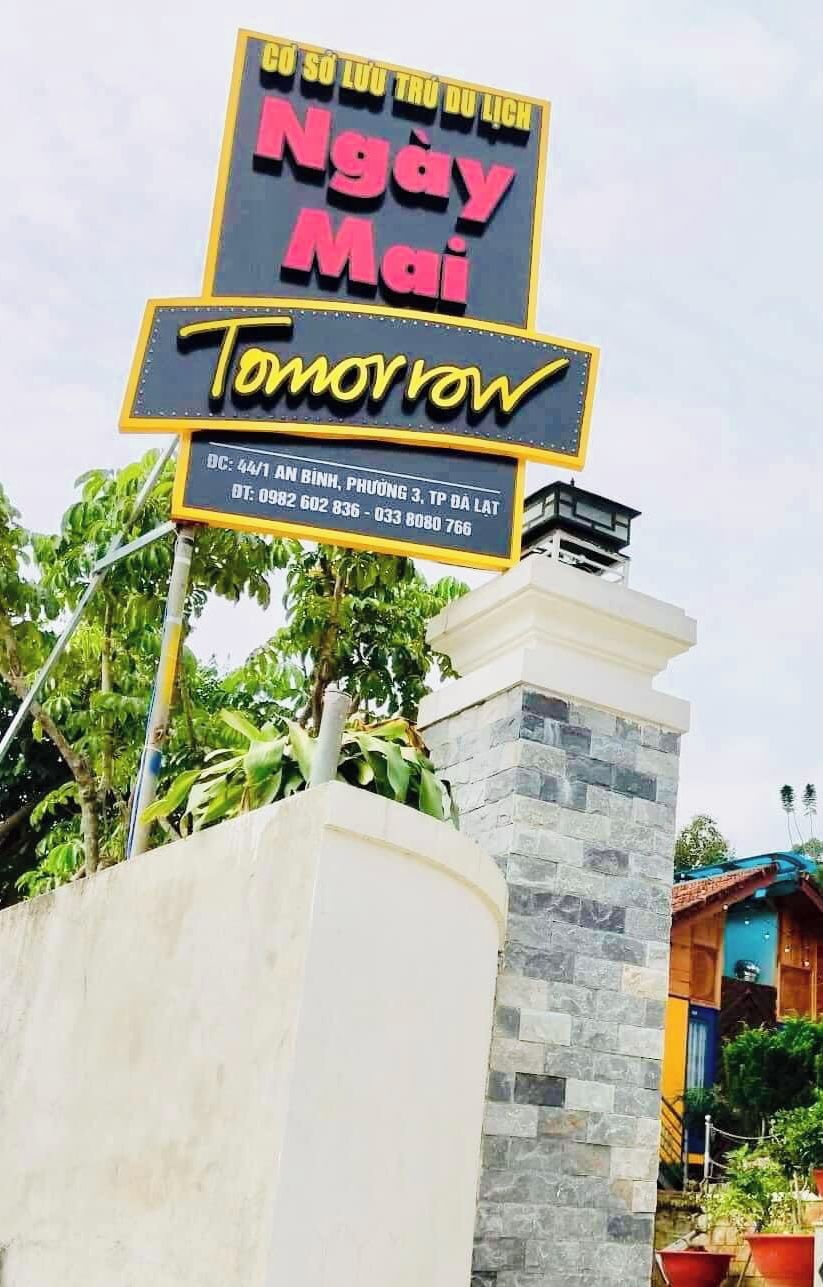 A sign with text in a foreign language, a contact number, and a partially visible address.