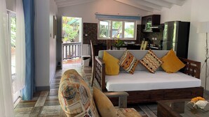 A spacious living area with a sofa, a dining table, and a kitchen in the background.