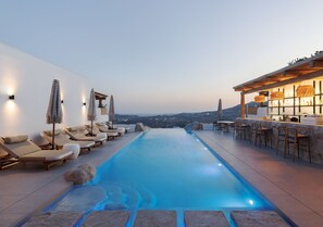 Una piscina al aire libre de temporada, sombrillas