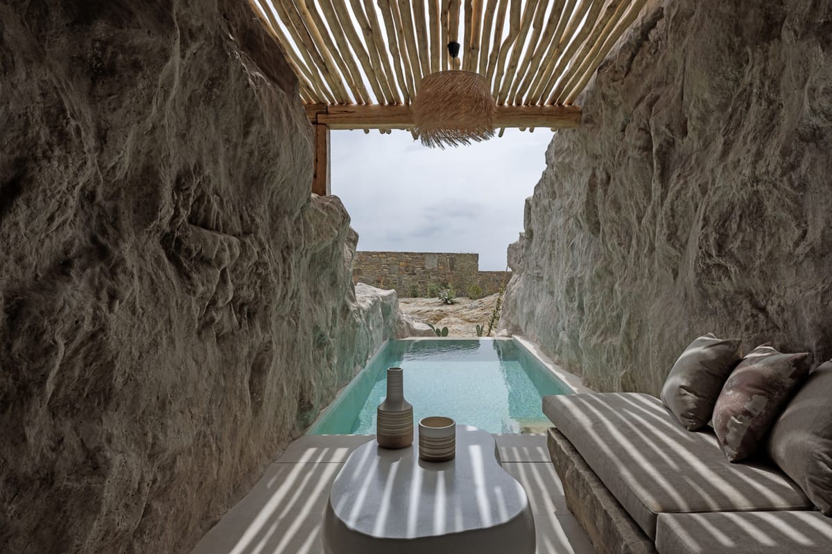 Un espace de détente avec piscine, une pergola en bois et un mur en pierre.