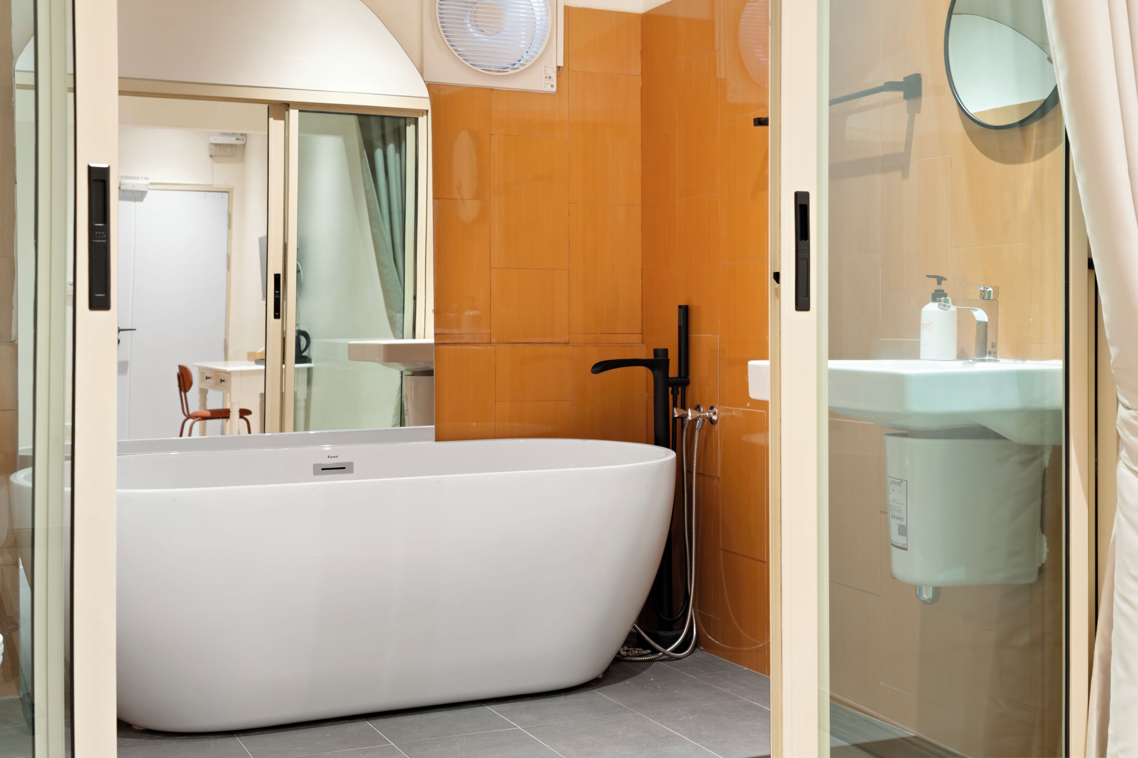 A modern bathroom with a freestanding bathtub, a glass shower enclosure, and a white sink.