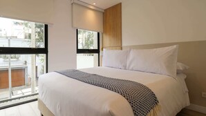 A modern bedroom with a large bed, a window with a view of the outside, and a wooden panel on the wall. - w* | Sophisticated 2BR with Balcony in Miraflores (Lima)