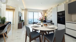 Un comedor moderno con una mesa redonda, sillas y un jarrón con flores.