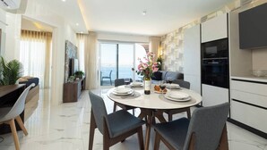 A modern dining area with a round table, chairs, and a vase of flowers. - Modern Bugibba apartment just steps from the beach  Featuring 1 bedroom, 1 bathroom, fast Wi-Fi, AC, Smart TV and a fully equipped kitchen — perfect for a relaxed seaside getaway (San Pawl il-Baħar)