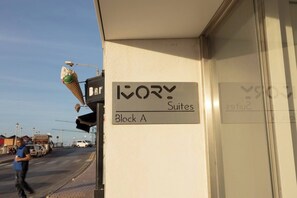 A hotel sign for 'Ivy Suites' in Block A, with a visible 'Bar' sign and a person walking by.