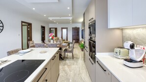 A modern kitchen with a central island, built-in oven, and a toaster.
