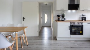 Ett modernt kök med vita skåp, en träbänkskiva och en svart ugn.