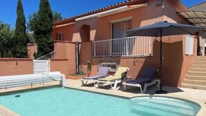 A swimming pool with lounge chairs and a covered patio area. - Villa Avec Piscine,barbecue,terrasse,proche de la Mer. Idéal Pour les Familles (Banyuls-dels-Aspres)