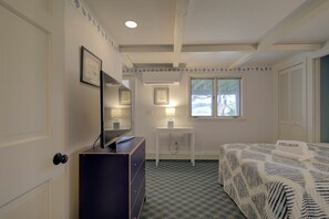 Un dormitorio con cama, cómoda, espejo, ventana y puerta.