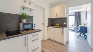 Une cuisine moderne équipée d’un four à micro-ondes, d’un évier et d’un coin repas avec une table et des chaises.