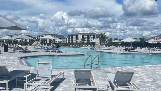 Uma área à beira da piscina com espreguiçadeiras e uma piscina.