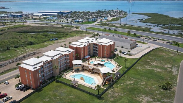 A hotel with multiple buildings, a swimming pool, and a view of the ocean. - Like New Killer Patio - Stunner Close to Beach (South Padre Island)