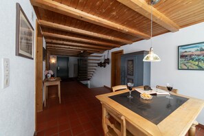 Een eethoek met een houten tafel, stoelen en een hanglamp.
