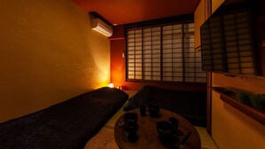 A traditional Japanese room with tatami flooring, a low table with tea utensils, and a sliding shoji screen door. - Oyadokinokuniya Isemachi (Nagasaki)