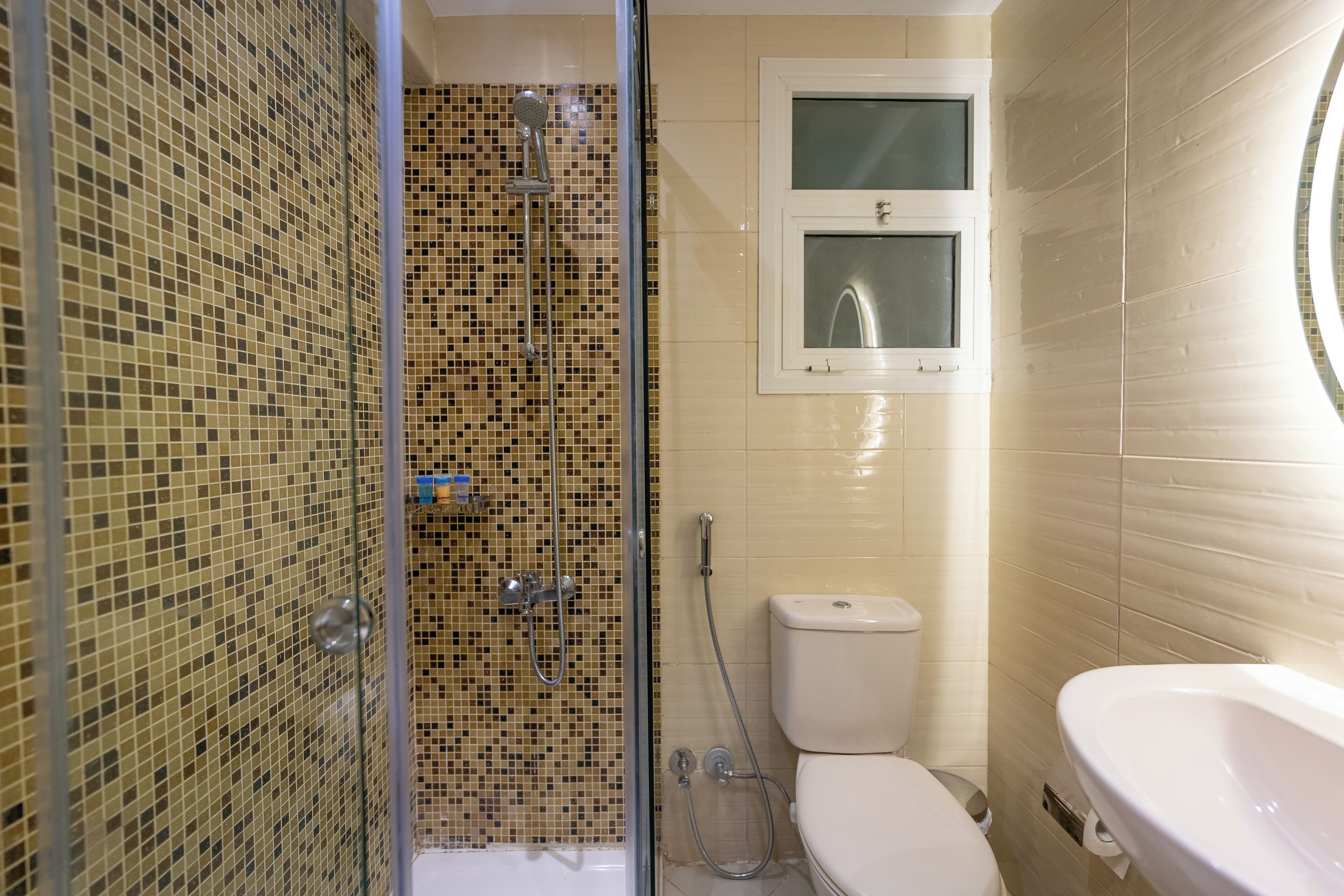 A bathroom with a shower, toilet, and sink.