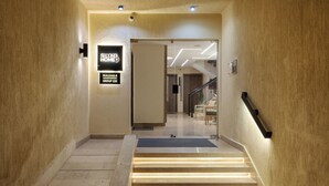 Entrada de un hotel con un cartel que indica 'SECOND HOME GROUP 133'.
