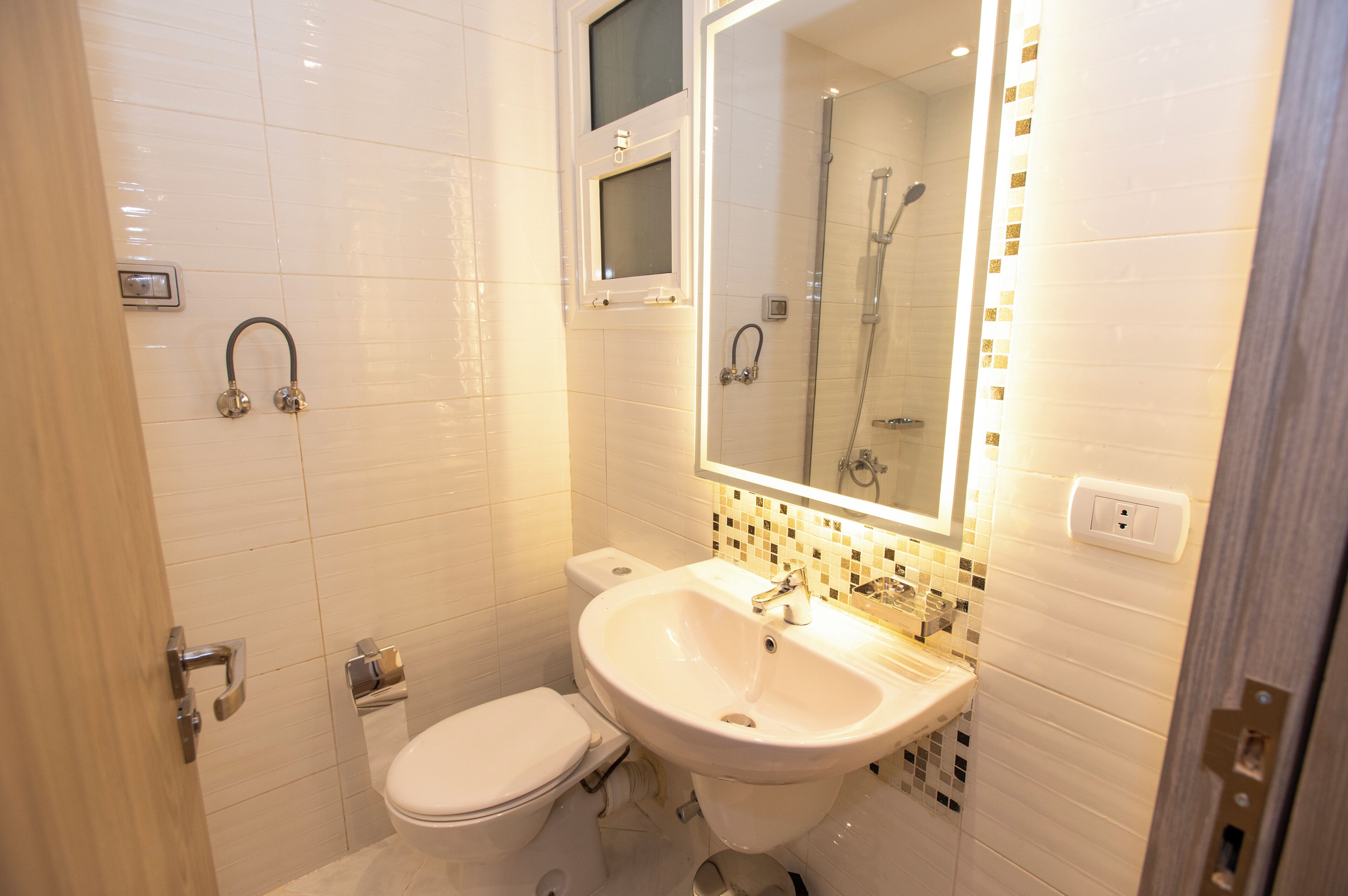 Un bany modern amb un vàter blanc, un lavabo i una dutxa.