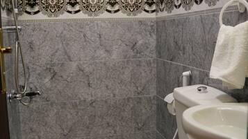 A bathroom with a shower, toilet, and sink.