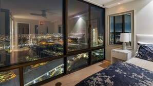 Une chambre avec vue sur la ville, comprenant un lit, une table de chevet et un miroir.