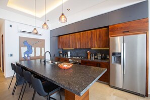 A modern kitchen with a central island, stainless steel appliances, and pendant lighting. - Oceanview Luxury: 2 BR in Amapas w/ Rooftop Pool (Puerto Vallarta)
