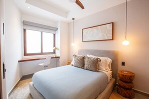 A modern bedroom with a large bed, a desk, and a window. - Oceanview Luxury: 2 BR in Amapas w/ Rooftop Pool (Puerto Vallarta)