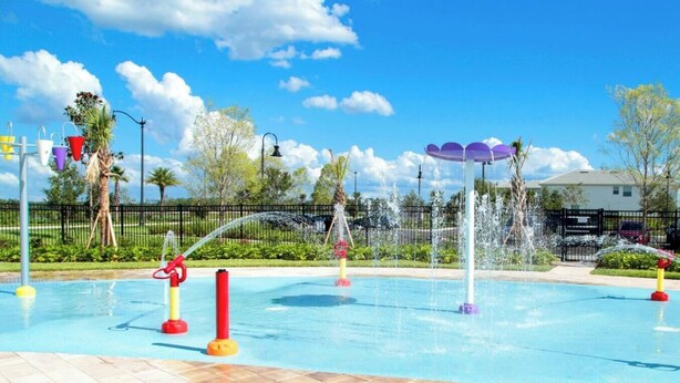 Une piscine dotée de plusieurs jets d’eau et d’une zone délimitée par une clôture.