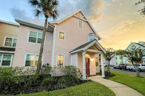 A two-story residential building with a front porch and a small attached garage. - 15103 Resort 2BR Condo Apt by Disney World Orlando (Kissimmee)