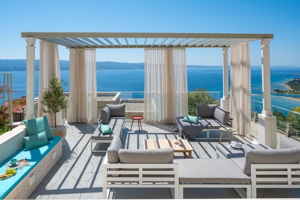 A cozy lounge area with curtains that offers a peaceful retreat to relax and appreciate the surrounding beauty and spectacular sunset and sea views - Casa GENI with a heated pool, 3 bedrooms, an organic garden, sea views (Borak)