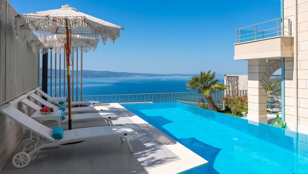 A poolside area with lounge chairs and a view of the sea. - Casa GENI with a heated pool, 3 bedrooms, an organic garden, sea views (Borak)