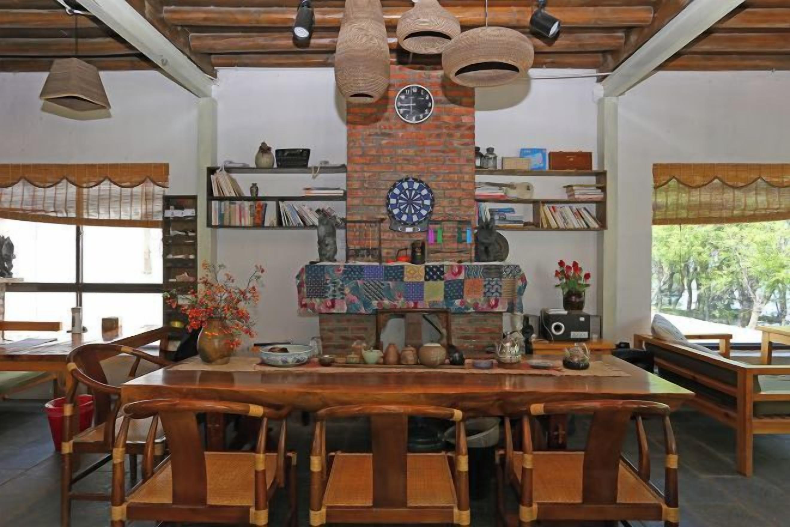 Un comedor con chimenea de ladrillo, muebles de madera y estantes con libros y objetos decorativos.