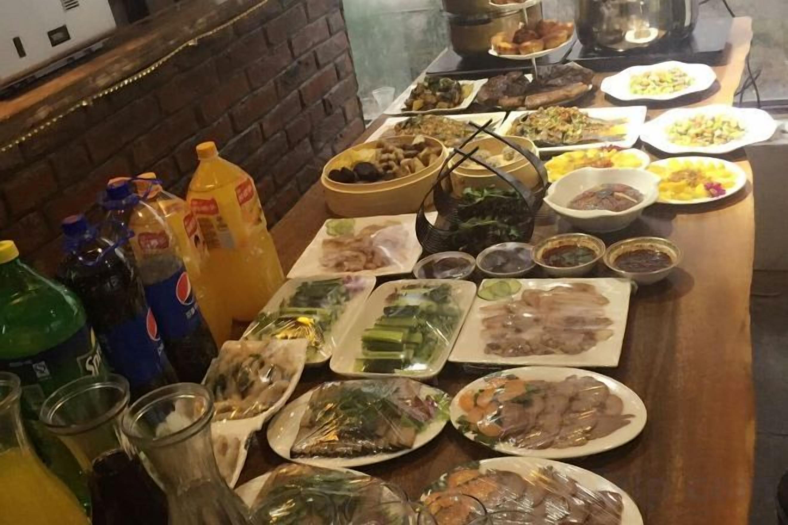 A table with various dishes and condiments, including plates of food, bowls, and bottles.