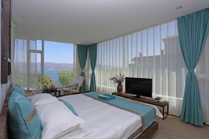 A bedroom with a large bed, a TV, and a view of the outdoors. - Haiyang Lanlan Erhai Garden Sea View Inn (Dali City)