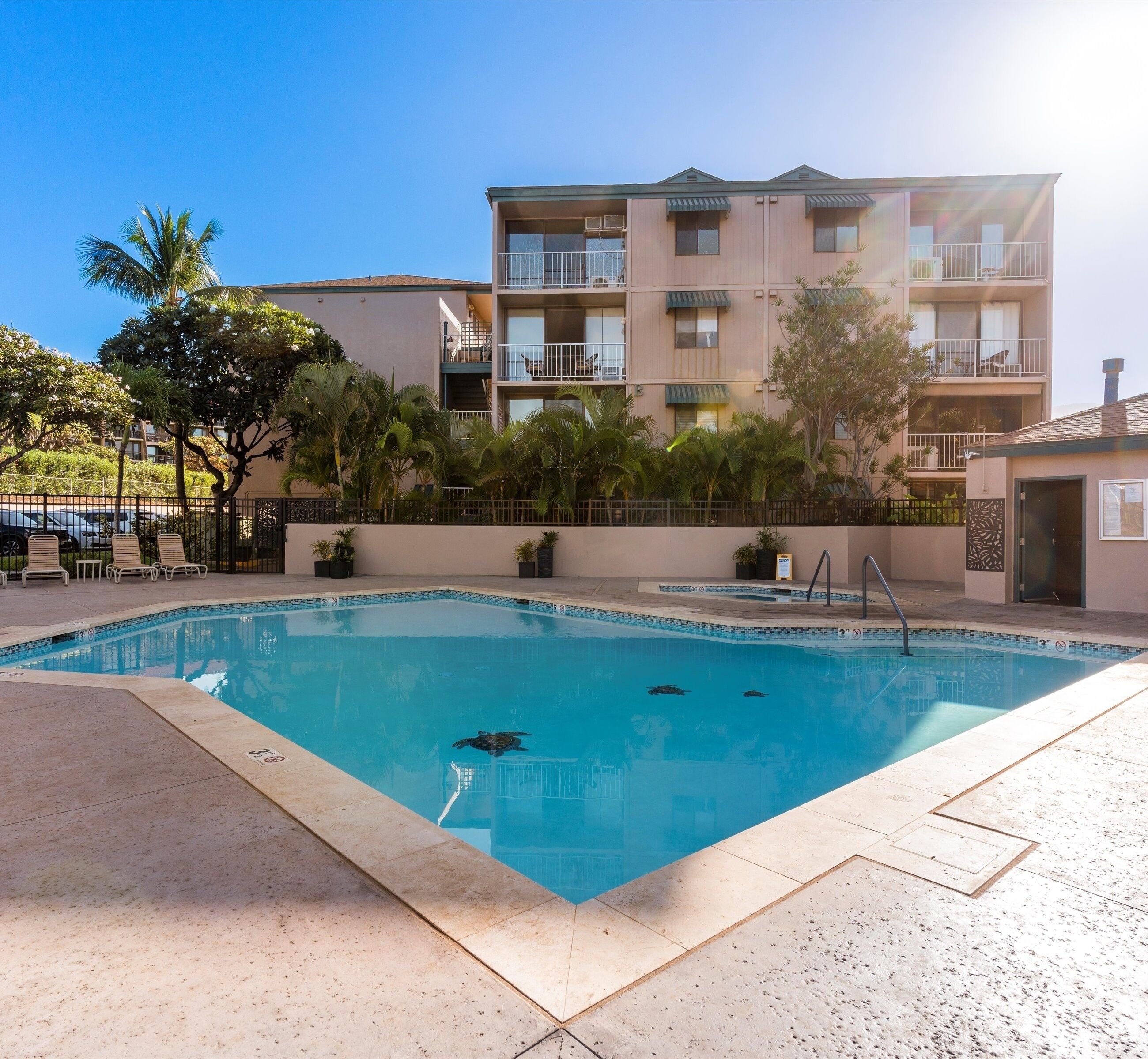A swimming pool with a clear blue water surface, surrounded by a tiled deck.