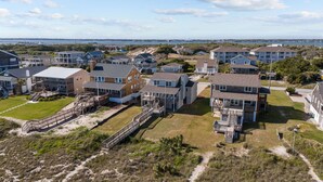 A coastal residential area with multiple two-story houses featuring balconies and a beach access walkway. - Highsmith Cottage (Oceanfront Home) (Atlantic Beach)