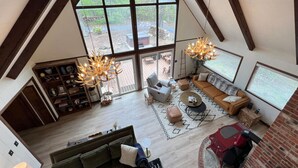 Een ruime loft met hoge plafonds, grote ramen en een gezellige zithoek met een open haard.