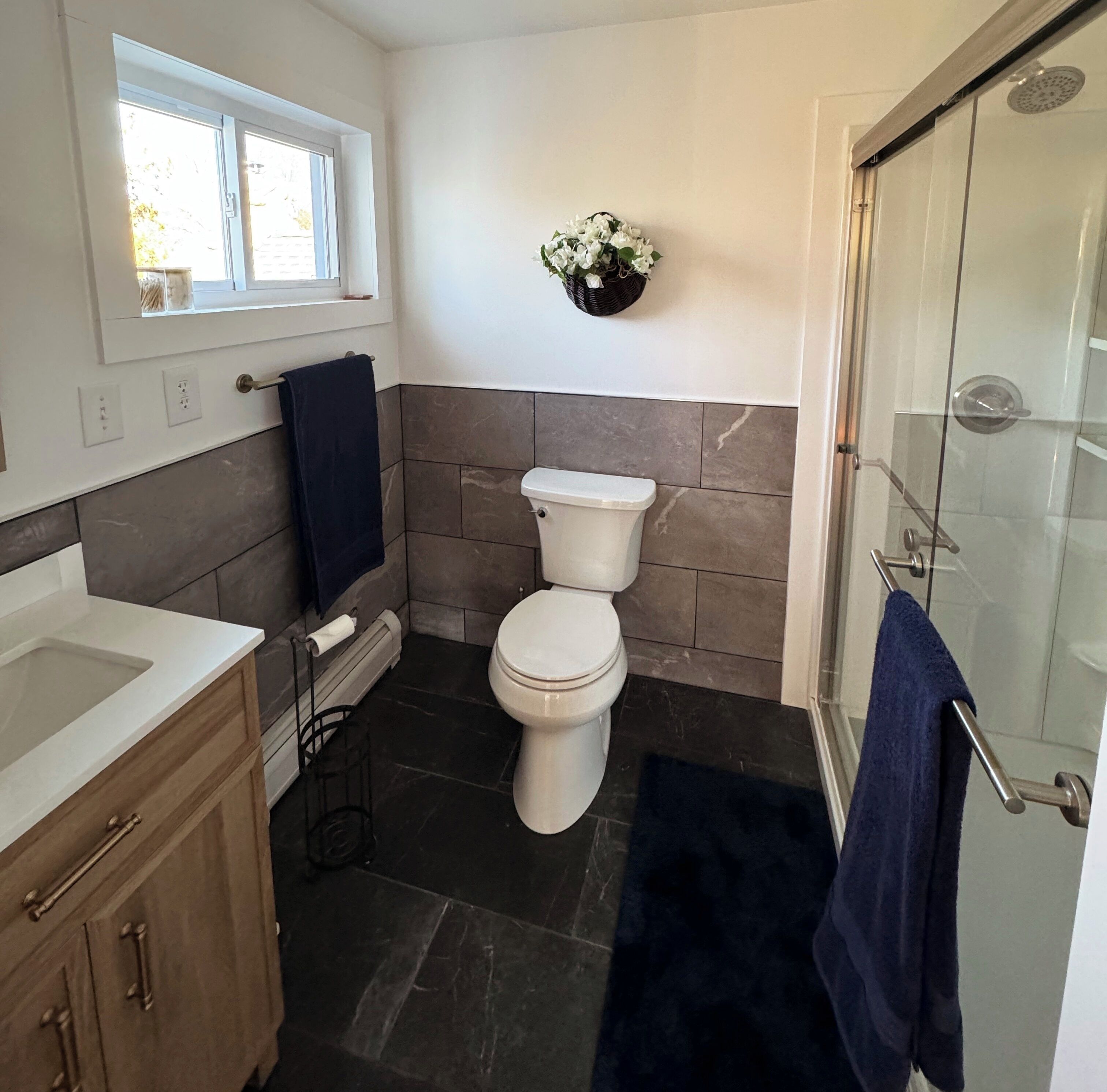 Une salle de bain moderne équipée de toilettes, d’un lavabo et d’une douche.