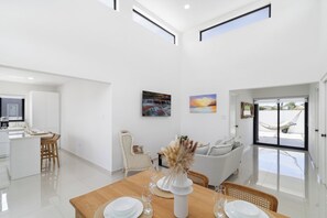 A modern interior with a dining area, kitchen, and living space. - Aruba Getaway: Luxe Villa, 3BR near Beach (Oranjestad)