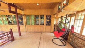 Ein Holzinterieur mit einem roten Sessel, einer hängenden Pflanze und einem Holzboden.
