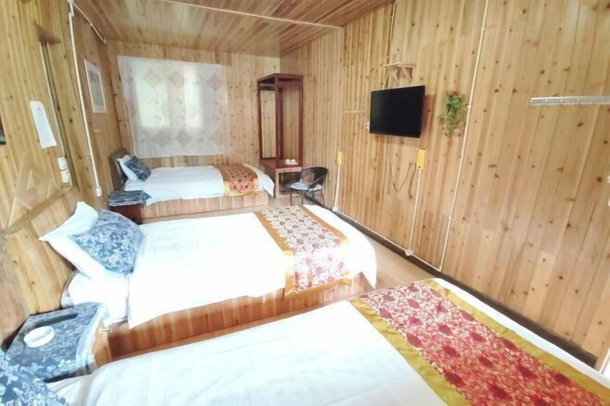 A wooden room with two beds, a TV, and a small table.
