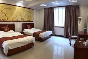 Habitación de hotel con dos camas, un cuadro grande, una ventana con cortinas y un escritorio con una silla.